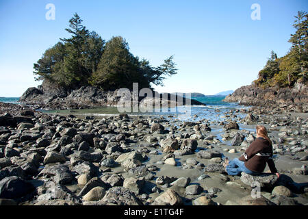 Una donna si gode della vista alla spiaggia di MacKenzie vicino a Tofino British Columbia Canada sull'Isola di Vancouver a Clayoquot Sound UNESCO Foto Stock