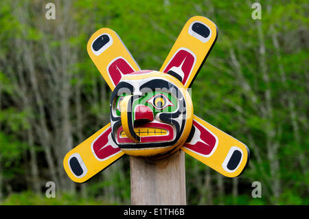 Un weathered sun totem maschera ad una sepoltura nella baia di avviso sulla isola di cormorani vicino all isola di Vancouver, BC. Foto Stock