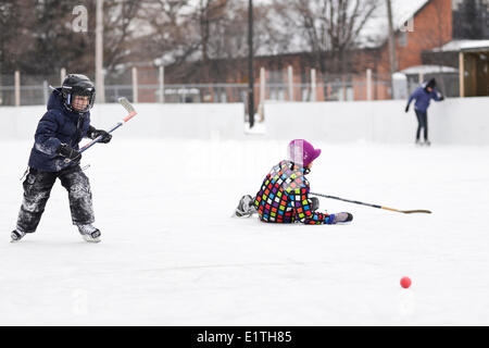 Ragazzi giocare hockey su ghiaccio, su di una pista di pattinaggio all'aperto, Winnipeg, Manitoba, Canada Foto Stock