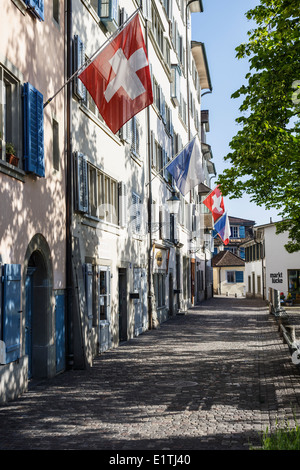 Un antico vicolo in Zurigo, decorata con Swiss e bandiere di Zurigo, Svizzera. Foto Stock