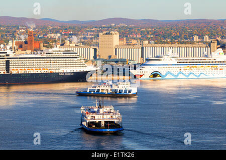 Traghetti attraversando il fiume San Lorenzo nella parte anteriore della nave da crociera attraccata a Quebec City, Quebec, Canada Foto Stock