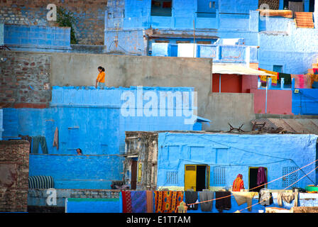 Una ragazza cammina lungo il suo tetto nella città blu, stato del Rajasthan, Jodhpur India Foto Stock