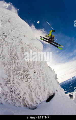 Un maschio di sciatore le catture di alcuni aria off una scogliera in Revelstoke Mountain Resort, Revelstoke Backcountry, BC Foto Stock