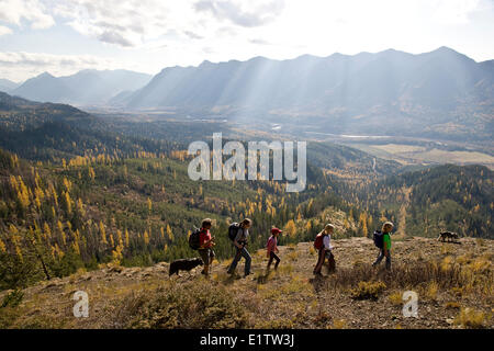 Giovane famiglia escursioni sul castello sentiero di montagna in autunno, Fernie, BC, Canada. Foto Stock