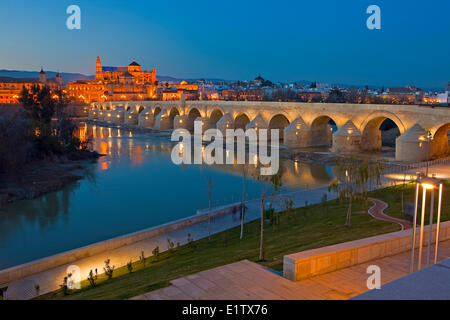 Puente Romano (ponte) che attraversa il Rio Guadalquivir (fiume) la Mezquita (Cathedral-Mosque) durante il crepuscolo nella città di Cordoba Foto Stock