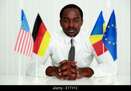 Grave african uomo seduto al tavolo in ufficio Foto Stock