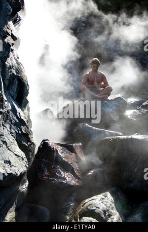 Un visitatore gode della cottura a vapore minerale naturale sorgenti calde di Hot Springs Cove nel Maquinna Parco provinciale sull'Isola di Vancouver Foto Stock