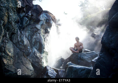 Un visitatore gode della cottura a vapore minerale naturale sorgenti calde di Hot Springs Cove nel Maquinna Parco provinciale sull'Isola di Vancouver Foto Stock