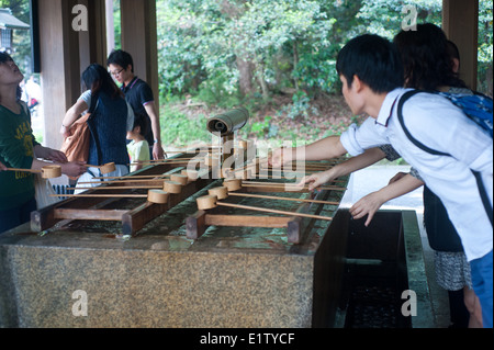 Tokyo Giappone 2014 - Toko Tempio di Meiji persone lavarsi le mani e il viso a la fontana di purificazione Foto Stock