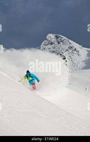 Un maschio di backcountry snowboarder spruzza un giro. Revelstoke Mountain Resort Backcountry, Revelstoke, BC Foto Stock