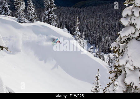 Un maschio di backcountry snowboarder spruzza un giro. Revelstoke Mountain Resort Backcountry, Revelstoke, BC Foto Stock