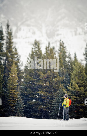 Un giovane uomo di fare escursioni con le racchette da neve a Peter Lougheed Parco Provinciale, Kananaskis AB Foto Stock