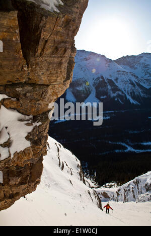 Un maschio di backcountry rider bootpacks su una ripida ed esposta coulior su Mt. Patterson, Icefields Parkway, Banff, AB Foto Stock