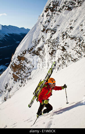 Un maschio di backcountry rider bootpacks su una ripida ed esposta coulior su Mt. Patterson, Icefields Parkway, Banff, AB Foto Stock