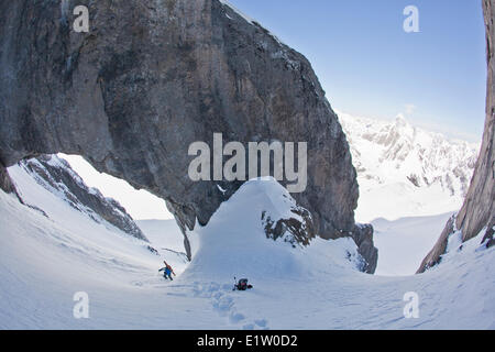 Un maschio di backcountry rider bootpacks su una ripida couloir con un unico arco calcareo in esso. Mt. Il francese Peter Lougheed provinciale Foto Stock