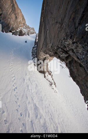 Un maschio di backcountry rider bootpacks su una ripida couloir con un unico arco calcareo in esso. Mt. Il francese Peter Lougheed provinciale Foto Stock