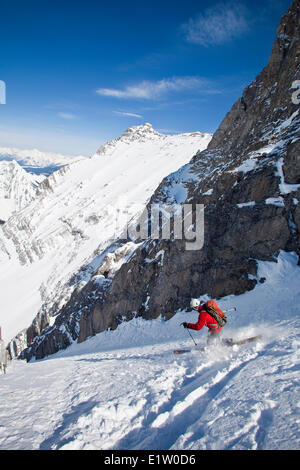 Un maschio di backcountry rider su tele sci scende un ripido couloir con un unico arco calcareo in esso. Mt. Il francese Peter Lougheed Foto Stock