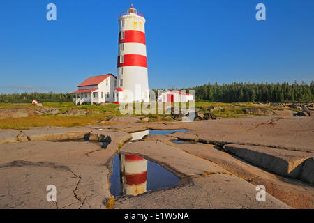 Faro riflessa nella piscina sul golfo di San Lorenzo, Baie Trinite, Quebec, Canada Foto Stock