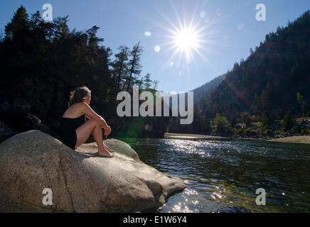 La donna si assorbisce i raggi del sole dal centro del fiume Similkameen a Bromley Rock Parco Provinciale, British Columbia, Canada Foto Stock