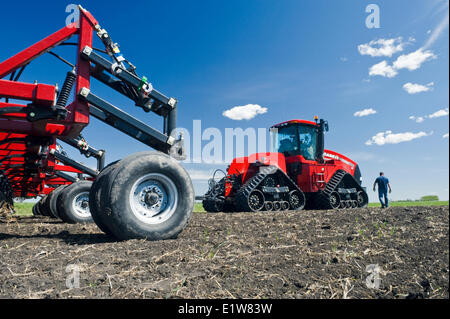 L'agricoltore che cammina verso il suo trattore Quadtrac e e aria fino a una seminatrice, vicino Lorette, Manitoba, Canada Foto Stock