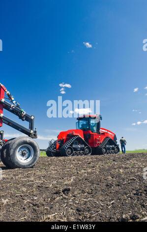 L'agricoltore che cammina verso il suo trattore Quadtrac e e aria fino a una seminatrice, vicino Lorette, Manitoba, Canada Foto Stock