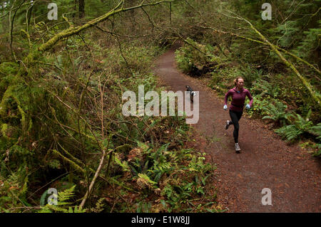 Donna trail running su Capilano Pacific Trail, il Capilano River Regional Park, North Vancouver, British Columbia, Canada Foto Stock