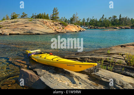 Giallo Kayak sulla riva del Georgian Bay, insediato a Porto, Ontario, Canada Foto Stock