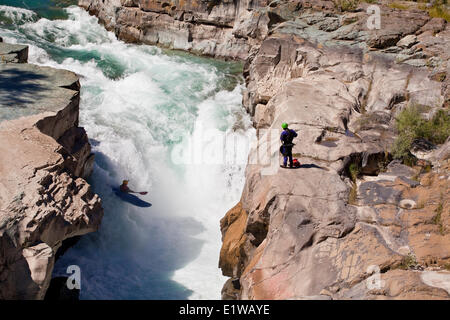 Un maschio di kayaker corre l'impegnativo della parte superiore Elk River, Fernie, BC Foto Stock