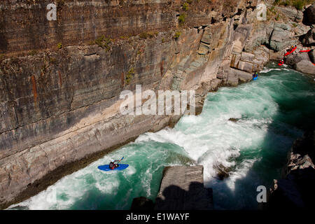 Un maschio di kayaker corre l'impegnativo della parte superiore Elk River, Fernie, BC Foto Stock