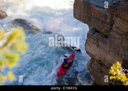 Un maschio di kayaker corre l'impegnativo della parte superiore Elk River, Fernie, BC Foto Stock