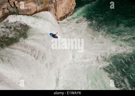 Un maschio di kayaker corre salto di fede, 30 piedi di cascata sulla tomaia Elk River, Fernie, BC Foto Stock