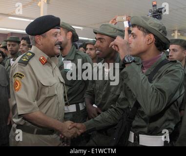 Tripoli, Libia. Decimo Giugno, 2014. Un soldato scuote le mani con un esercito ufficiale prima di salire a bordo di un aereo in Mitiga aeroporto di Tripoli, in Libia, il 10 giugno 2014. Un lotto di ribelli che hanno aderito alla Libia dell esercito regolare a sinistra per la Gran Bretagna di ricevere una formazione in Libia esercito-piano di ricostituzione. © Hamza Turkia/Xinhua/Alamy Live News Foto Stock