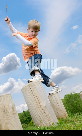 Ragazzo giovane imparare in equilibrio su montanti a passo Foto Stock