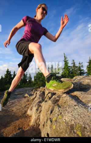 Femmina trail running sulla cabina Lago Trail sulla montagna nera. Cypress Parco Provinciale. West Vancouver British Columbia Canada Foto Stock