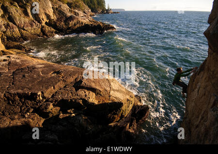 Arrampicata su roccia sopra l'oceano al Lighthouse Park. West Vancouver, British Columbia, Canada Foto Stock