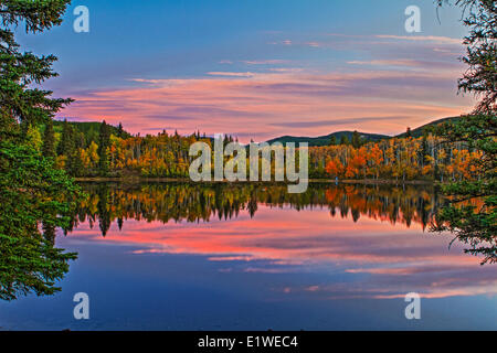 Sibbald Lago come si vede nella caduta di sunrise. Bella riflessioni del cielo e alberi nell'acqua. Foto Stock