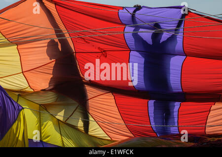 Un equipaggio di volo planato si stagliano tenendo un paracadute preparando per sollevare un client skyward off la costa vietnamita di Nha Trang, Foto Stock