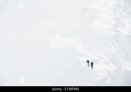 Due sciatori backcountry salire una dorsale scanalato di qua il picco nella Kootenays vicino a Nelson, British Columbia Foto Stock