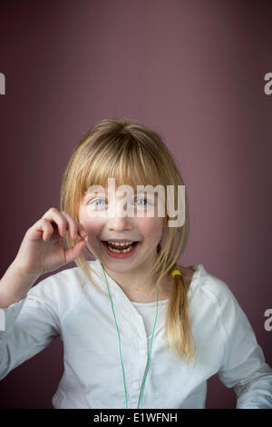 Sorridente bambina che mostra il suo primo dente allentato Foto Stock