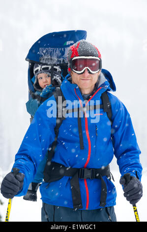 Un uomo e il suo giovane figlio godetevi una passeggiata nella neve, montagne Monashee, British Columbia Foto Stock