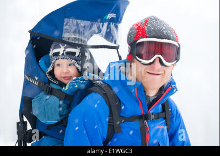 Un uomo e il suo giovane figlio godetevi una passeggiata nella neve, montagne Monashee, British Columbia Foto Stock