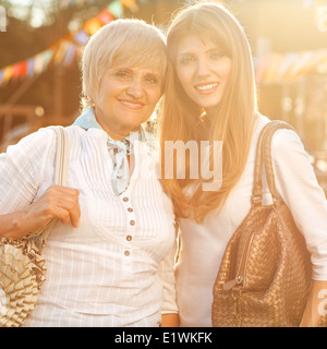 Adulto madre e figlia dopo lo shopping a piedi giù per la strada e parlare Foto Stock