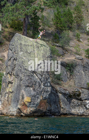 I ragazzi del salto di rocce di grandi dimensioni nel lago.Idaho USA Foto Stock