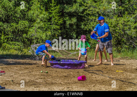 Per adulti e bambini in acqua playfull lotta , su una calda e soleggiata giornata estiva. Cranbrook, British Columbia, Canada.