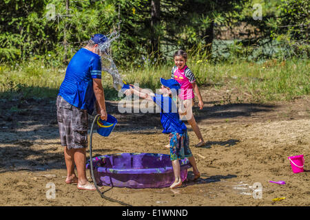 Per adulti e bambini in acqua playfull lotta , su una calda e soleggiata giornata estiva. Cranbrook, British Columbia, Canada.
