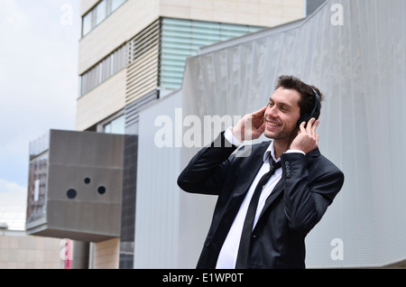 Imprenditore ascoltando musica sulle cuffie Foto Stock