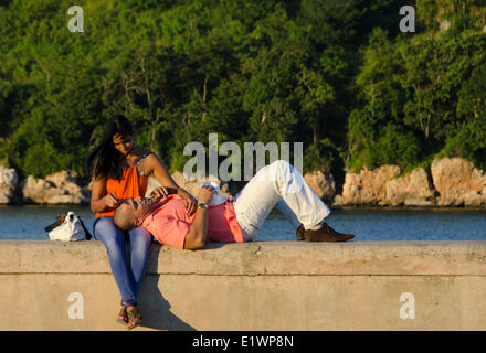 Coppia giovane sul Seawall del porto di Havana, Cuba Foto Stock