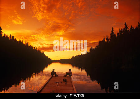 Ragazzi relax su dock dopo la pesca, anatra montagna Parco Provinciale, Manitoba, Canada Foto Stock