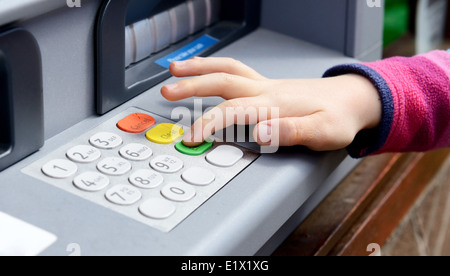 Dito che preme il pulsante invio om bancomat Foto Stock