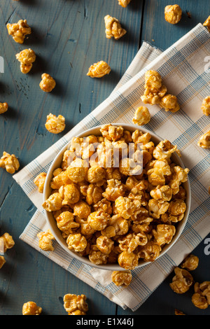 Golden caramello pop corn in sacchetti di carta in un bianco scatola di  legno Foto stock - Alamy